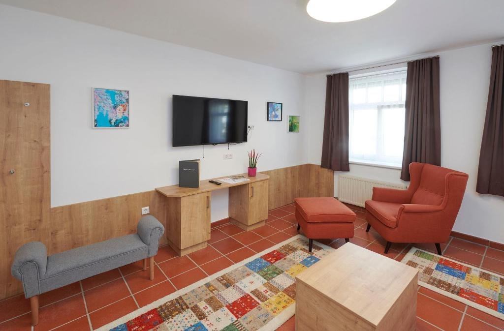 Wohnbereich im Familienzimmer mit Sesseln, Fernseher und gemütlicher Atmosphäre