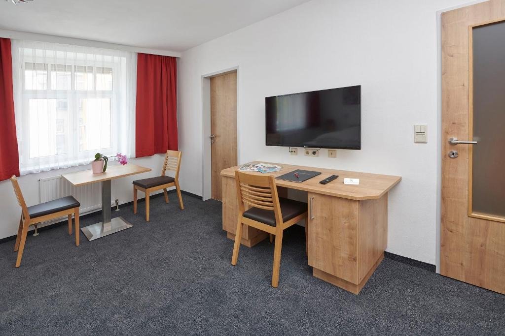 Arbeitsbereich im Studio-Apartment mit Schreibtisch und Fernseher