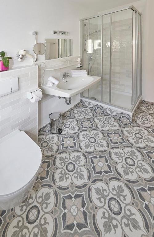Klassiches Badezimmer mit Dusche und dekorativem Fliesenboden