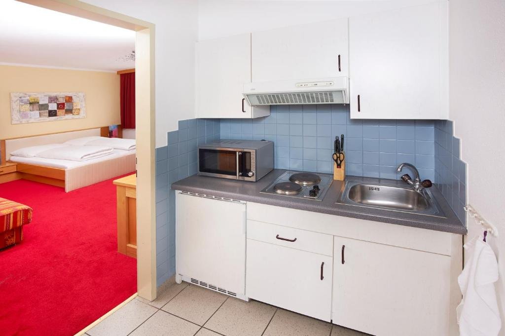 Küchenzeile im Studio-Apartment mit Kochfeld, Mikrowelle und Kühlschrank