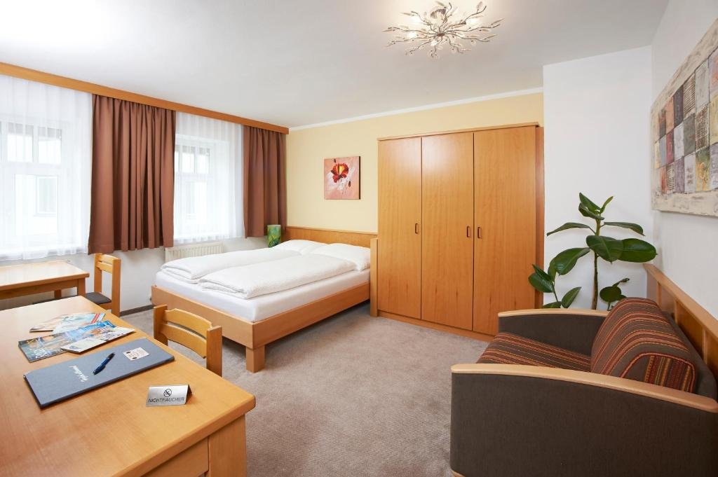 Gemütliches Doppelzimmer mit Doppelbett, Sitzgelegenheit und Schreibtisch