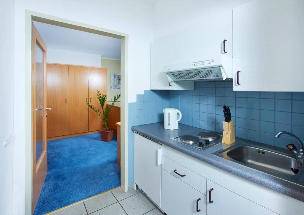 Küchenzeile im Einzelzimmer mit Kochfeld, Wasserkocher und Kühlschrank