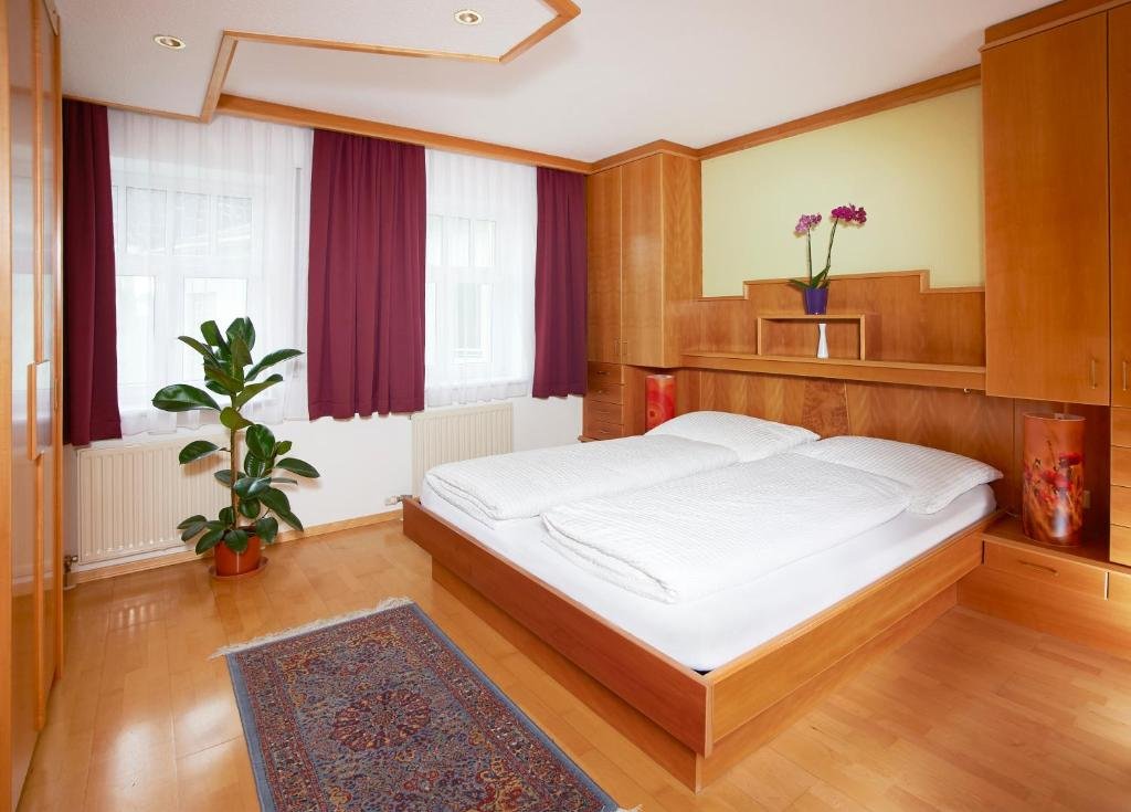 Schlafzimmer der Ferienwohnung mit Doppelbett und hochwertigen Holzmöbeln
