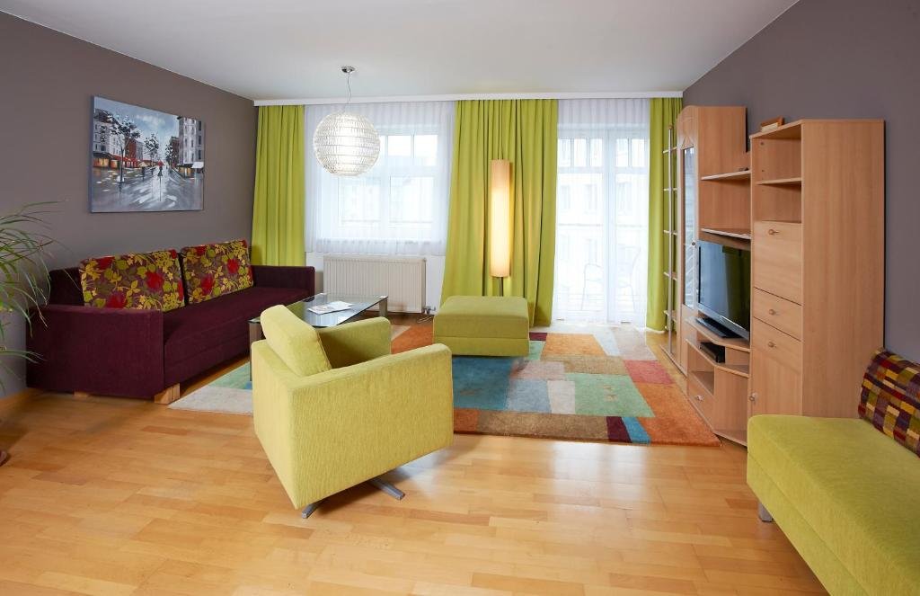 Wohnzimmer der Ferienwohnung mit Sofa, Sesseln und Fernseher